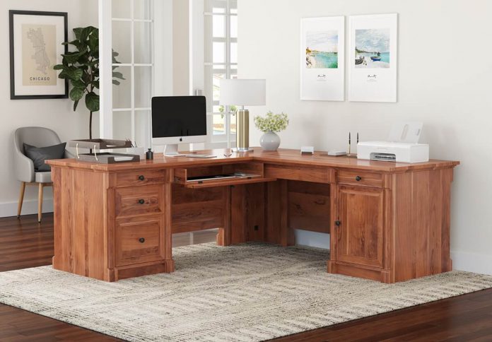 clutter free solid wood L shaped desk in a office.