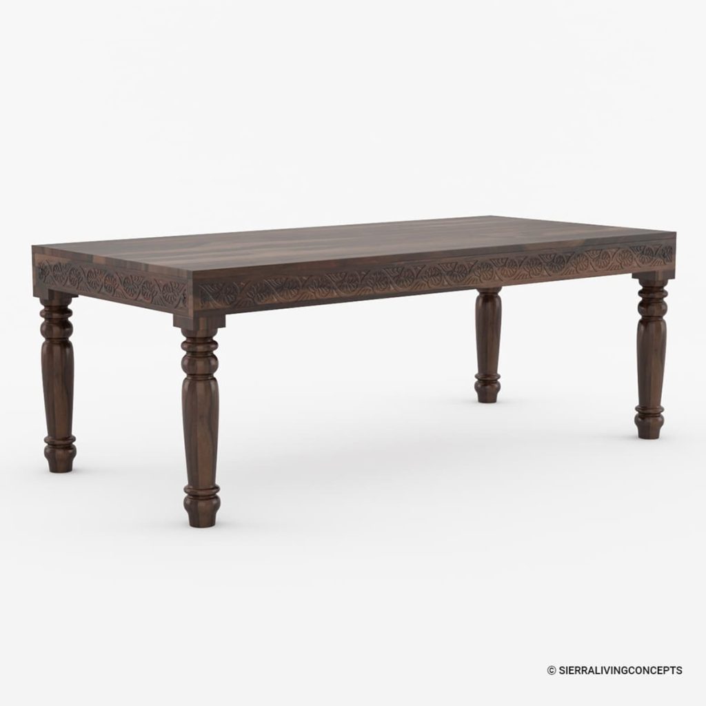 Carved dark wood dining table with turned legs and a floral hand carved apron.